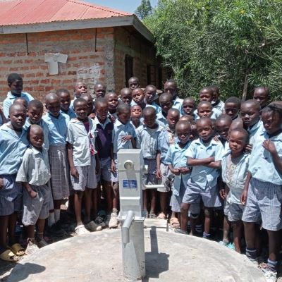 Village school students alongside their new well