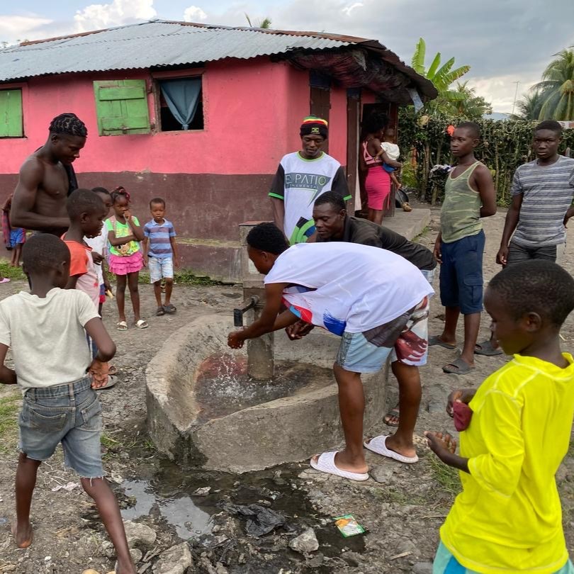 Villagers around newly repaired pump