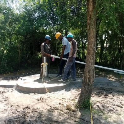 Team installing a hand pump on the new well