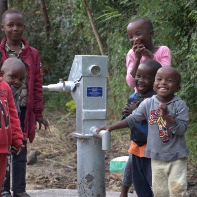 Happy village kids alongside new village well