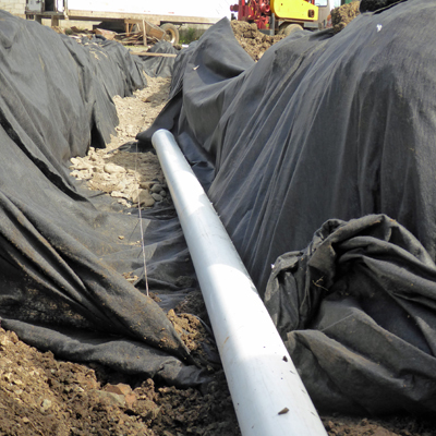 Laying 4" PVC with drainage holes for overflow from Workshop Roof