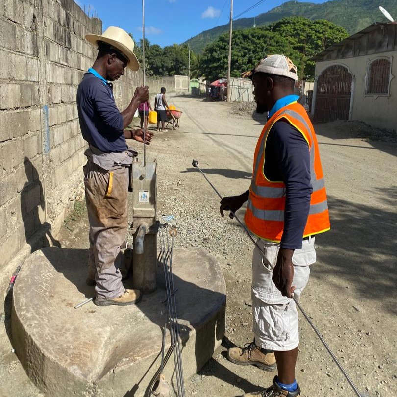 Team at work repairing handpump