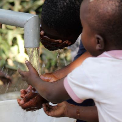 Children taking a drink from the repaired pump