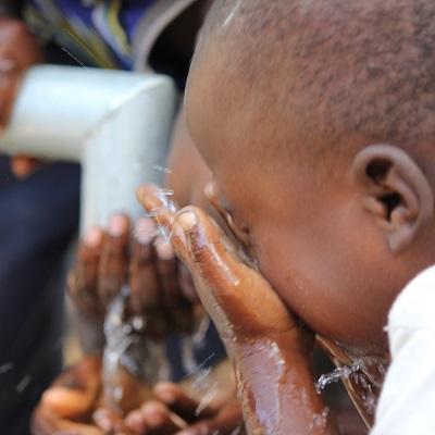 Child enjoying water from newly repaired pump