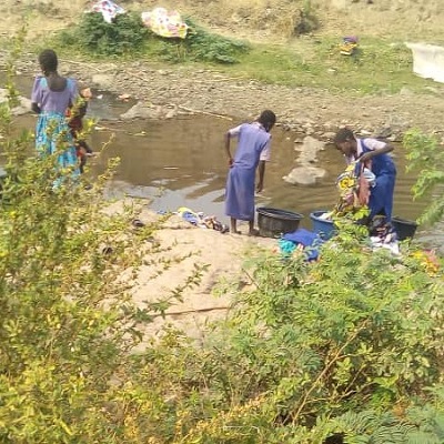 Children drawing water from old source
