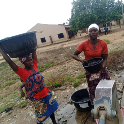 Women drawing water from repaired pump