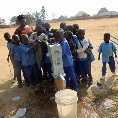 Children Gather Around Repaired Pump