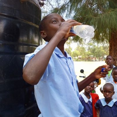 A student enjoying clean drinking water