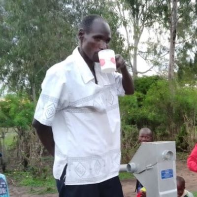 Villager enjoying clean and safe water from the rehabilitated village well